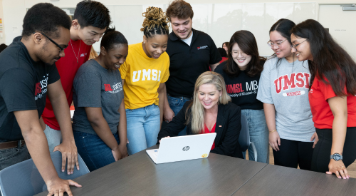 Dr. Cindy Goodwin-Sak with UMSL students at table